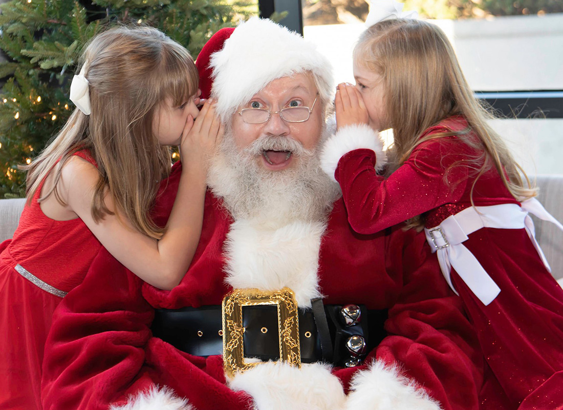 Laurie Campos Insurance Welcomes a Visit From Santa - Two Girls Whispering to Santa Clause